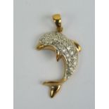 A 9ct gold and diamond dolphin pendant having yellow metal tail and fins,