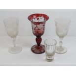 Four assorted glass items including a ruby glass acid etched Bacchus wine glass having vines and