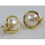 A pair of 18ct gold mabé pearl earrings with single round cut diamond to the yellow metal mount