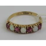A 9ct gold ruby and opal ring having three round opal cabachons separated by four round cut rubies,