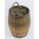 A coopered liquor barrel having brass banding and hinged lid,
