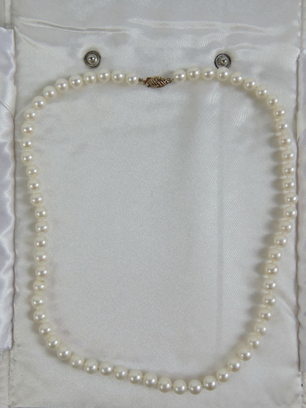 A string of individually knotted cultured freshwater pearls having 9ct gold clasp with single