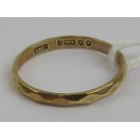 A 9ct gold band having faceted pattern throughout, hallmarked 375, size V, 2.