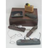 A vintage mahogany box containing a quantity of vintage spectacles, some in cases, a/f,