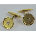 A pair of 18ct gold cufflinks in the form of buttons and having white gold 'stitching',