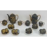 Two black ground and gilded Japanese tea services each comprising six cups and saucers,