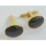 A pair of 18ct gold cufflinks having faceted oval matt black onyx cabachon to front, hallmarked 750,