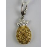 An 18ct white gold charm in the form of a pineapple encrusted with yellow sapphires with diamonds