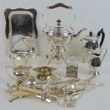 A silver plated teapot raised on a H shaped base over a spirit burner,