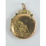 A 9ct gold locket of circular form having floral engraving to front and back, slightly a/f,