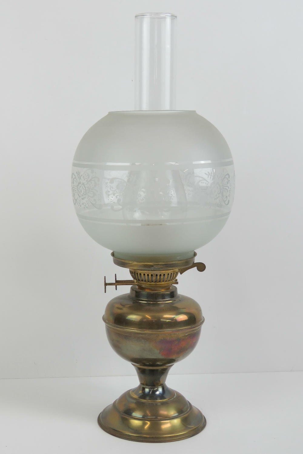 A brass oil lamp with glass chimney and