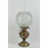 A brass oil lamp with glass chimney and