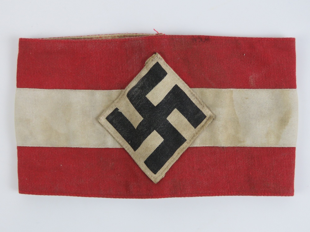 A WWII German swastika armband, SS issue having maker marks upon and labels with military stamps,