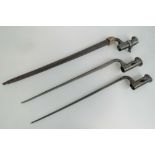 An antique socket type rifle bayonet in scabbard dated 1881, plus two others. Three items.