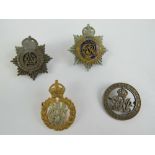 A quantity of badges including; a GR King & Empire Services Rendered badge. Four items.