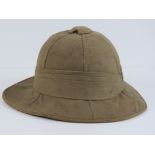 A vintage canvas covered pith helmet complete with original leather brow band.