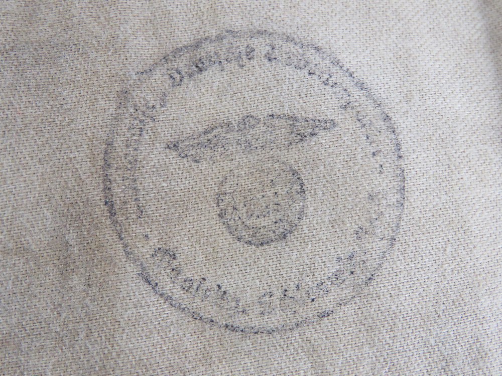 A WWII German swastika armband, SS issue having maker marks upon and labels with military stamps, - Image 3 of 4