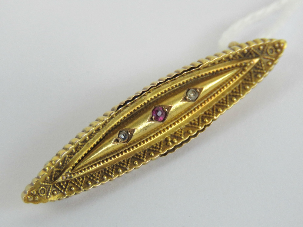 A Victorian 15ct gold brooch having central ruby flanked by twin diamonds, slightly a/f,