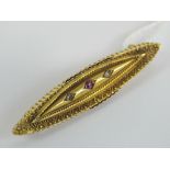 A Victorian 15ct gold brooch having central ruby flanked by twin diamonds, slightly a/f,