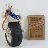 A reproduction Michelin Mr Bibendum on tyre figurine together with a vintage paper manual.