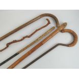 Five assorted walking sticks including a decorative stripped bark cane, bamboo long stick,