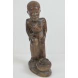 An African rosewood carving depicting a female with cooking pot,