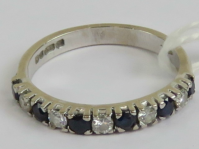 An 18ct white gold half eternity ring having alternating round cut sapphires and diamonds,