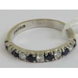 An 18ct white gold half eternity ring having alternating round cut sapphires and diamonds,