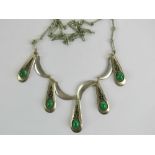A silver and green stone pendant having five teardrop shaped panels each set with green cabachon