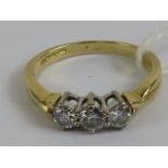 An 18ct gold three stone diamond ring each round cut brilliant diamond claw set in white metal,