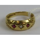 An Edwardian 18ct gold gypsy style ring having central diamond flanked by twin rubies,