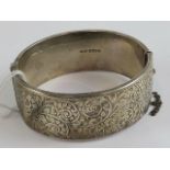 A HM silver hinged bangle having floral engraving throughout, hallmarked Birmingham 1946.