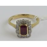 A 9ct gold ruby and diamond cluster ring having central octagonal cut ruby surrounded by a gallery