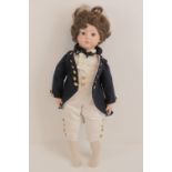 A contemporary porcelain headed doll in the form of a young Naval Officer, glass eyes,