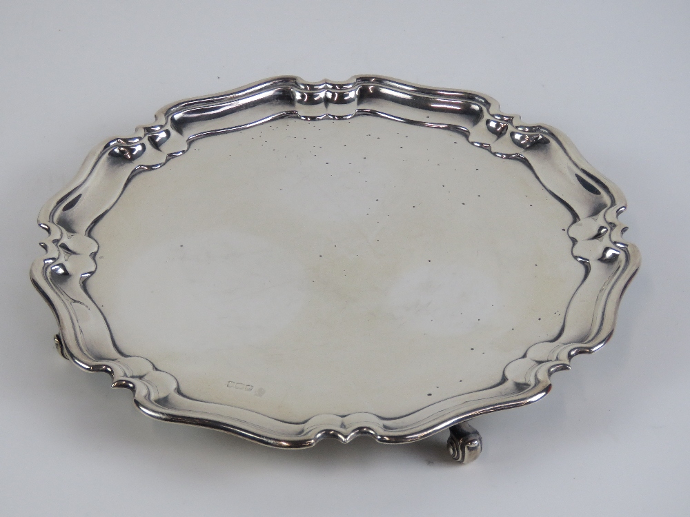 A HM silver salver having pie crust edge and raised over four scroll feet,