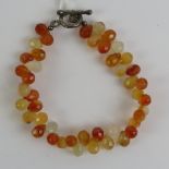 A carnelian bracelet having teardrop faceted carnelian stones of various shades orange-white,