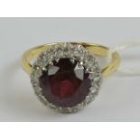 An 18ct gold garnet and diamond and cocktail ring, the round cut garnet approx 3.4ct (approx 9.