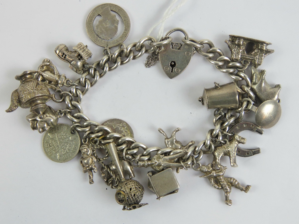 An HM silver curb link charm bracelet having heart padlock clasp and assorted silver and white