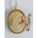 A 9ct gold cameo brooch/pendant having carved shell portrait of a young lady with floral bouquet