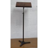 A free standing mahogany adjustable music stand on triform cast metal base.