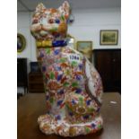 AN ORIENTAL PORCELAIN SEATED CAT DECORATED IN IRON RED AND COLOURED ENAMEL FLOWERS, SIX CHARACTER