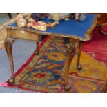 A GEORGIAN STYLE WALNUT SERPENTINE FOLD OVER CARD TABLE WITH GILT HIGHLIGHTED CARVED DECORATION ON