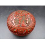 A CHINESE CINNABAR LACQUER BUN SHAPED BOX, THE COVER WORKED WITH A ROUNDEL OF TWO SAGES BELOW AND