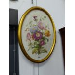 A BISQUE PORCELAIN OVAL PLAQUE PAINTED WITH A BUNCH OF FLOWERS WITHIN GILT FRAME. 53.5 x 39cms.
