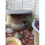 A PAIR OF CAST IRON CAMPAGNA GARDEN URNS AND ASSOCIATED COMPOSITE STONE PLINTHS.
