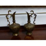 A PAIR OF INDIAN GILDED BRONZE EWERS WITH FOLIATE SCROLL HANDLES, CHASED ANIMAL AND FOLIATE