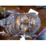A GROUP OF ORIENTAL FIGURES AND MASKS, MOST CARVED HARDWOOD WITH INLAID DETAILS TO INCLUDE FOO