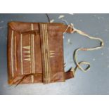 A NATIVE AMERICAN EMBOSSED LEATHER BAG SEWN WITH WHITE LEATHER LINES AND CONES IN RED, WHITE AND