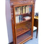 A GLAZED MAHOGANY BOOKCASE WITH CARVED DECORATION. W.96 x H.155 x D.37cms.