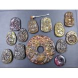 A COLLECTION OF THIRTEEN CHINESE STONE PENDANTS DECORATED IN RELIEF WITH ANIMAL AND FIGURAL
